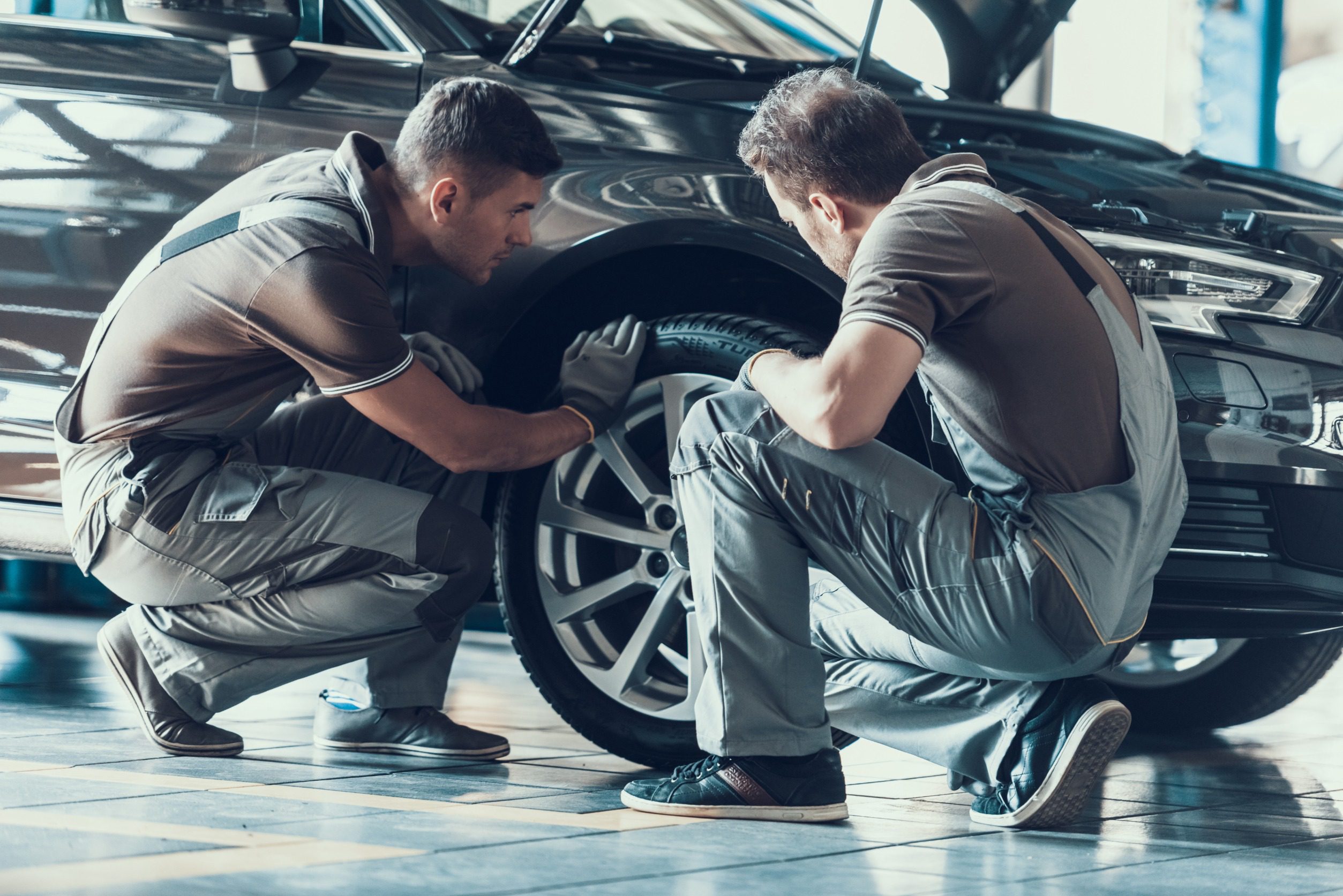 Two man working on the car tyres