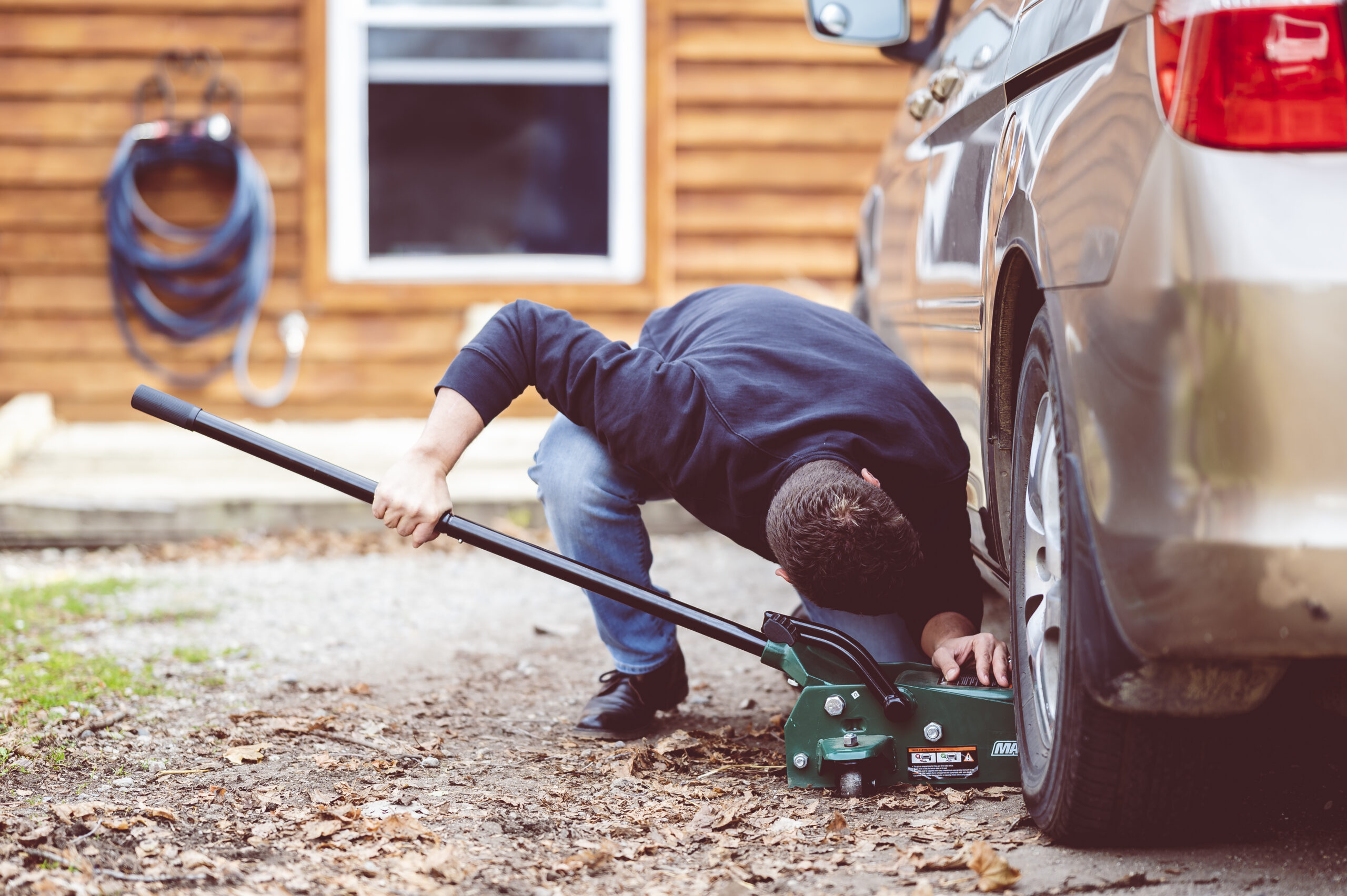 Closeup shot of a man repairing a car with a tool