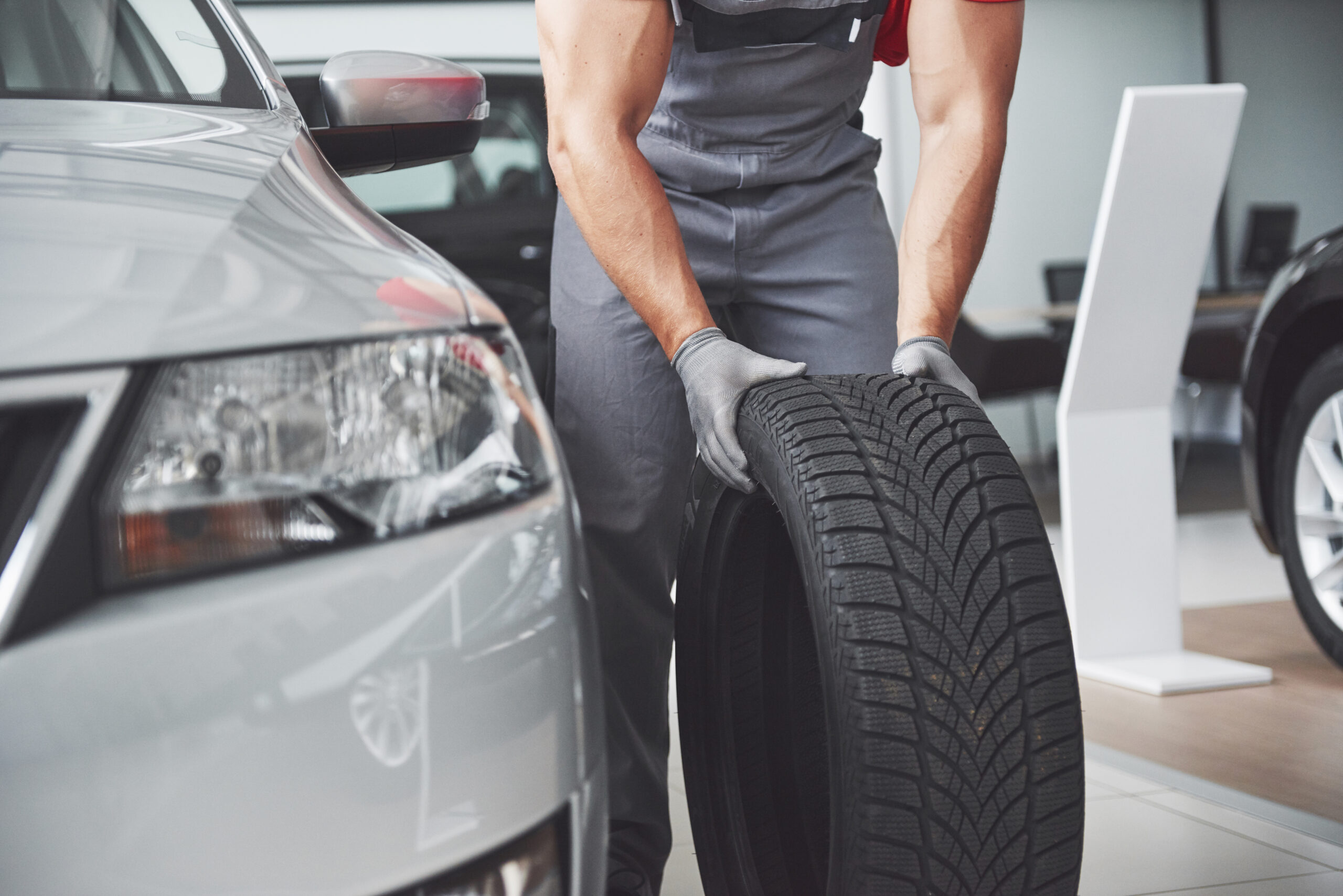 Mechanic holding a tire tire at the repair garage. replacement of winter and summer tires